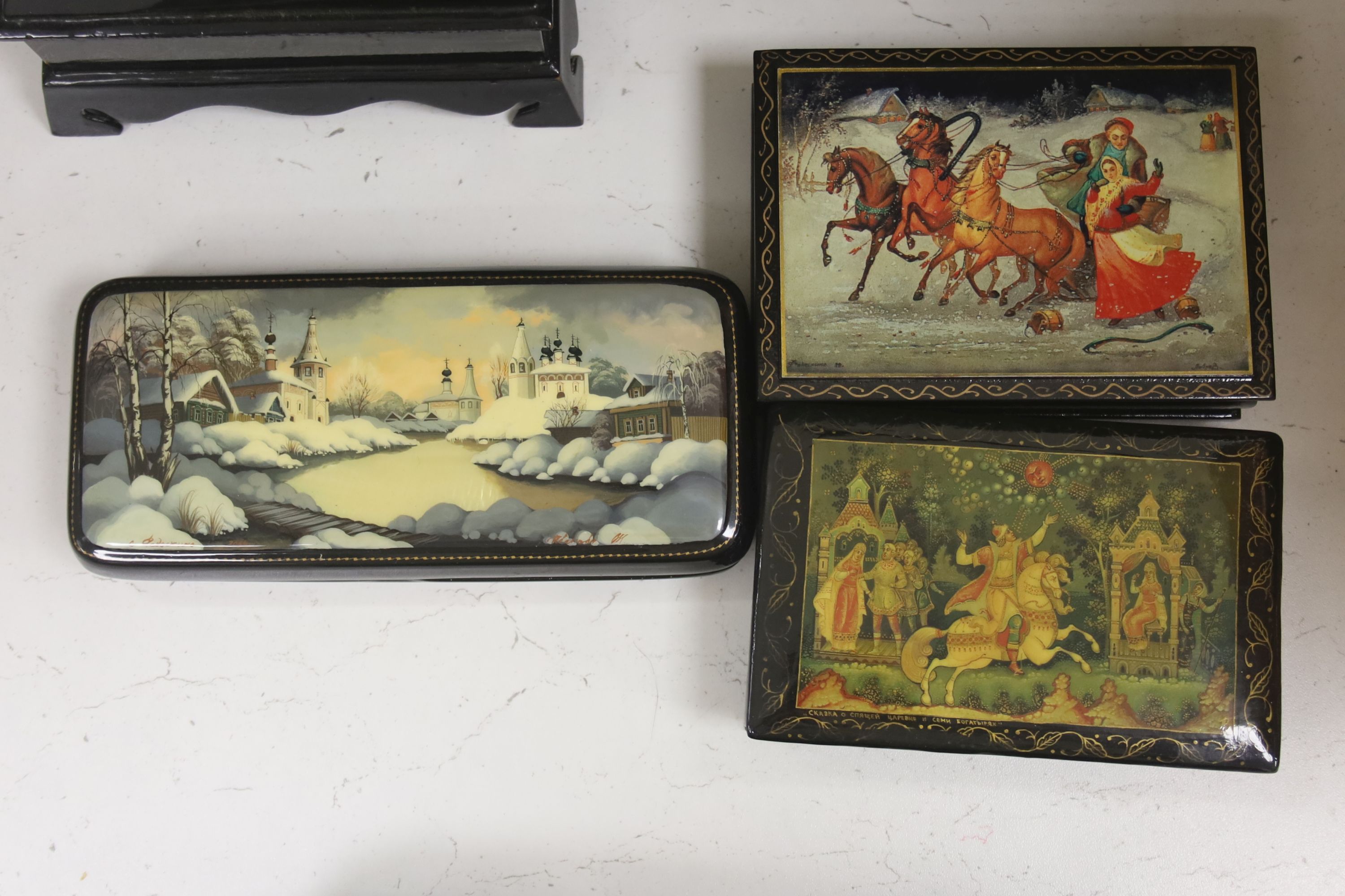 A collection of seven Russian painted lacquer boxes, largest raised on bracket base 15 x 20cm 9.5cm high